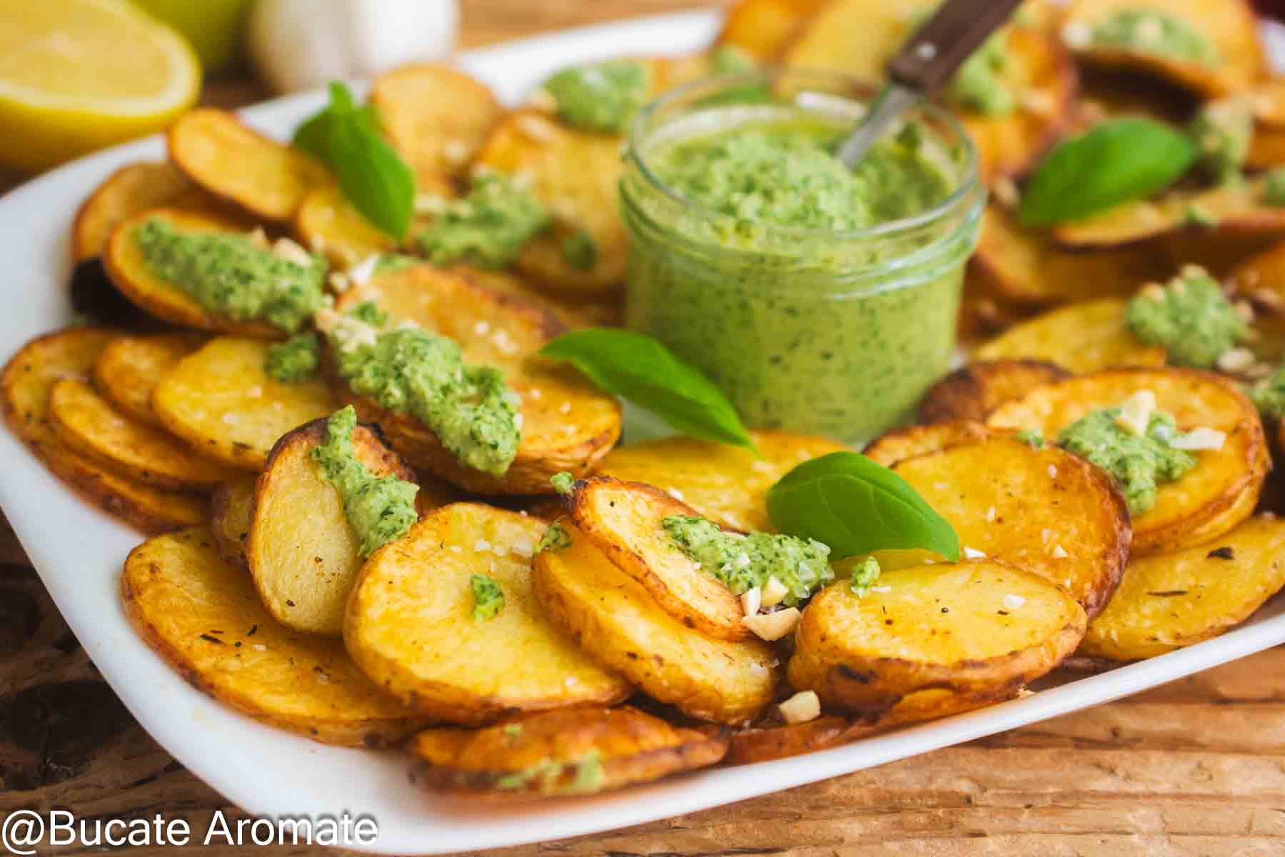 Platou cu cartofi rondele aurii la cuptor, pesto verde de busuioc și caju crocant
