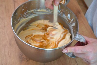 Cremă de dulce de leche și unt de arahide încorporată în frișcă bătută, pentru înghețată de caramel făcută acasă.