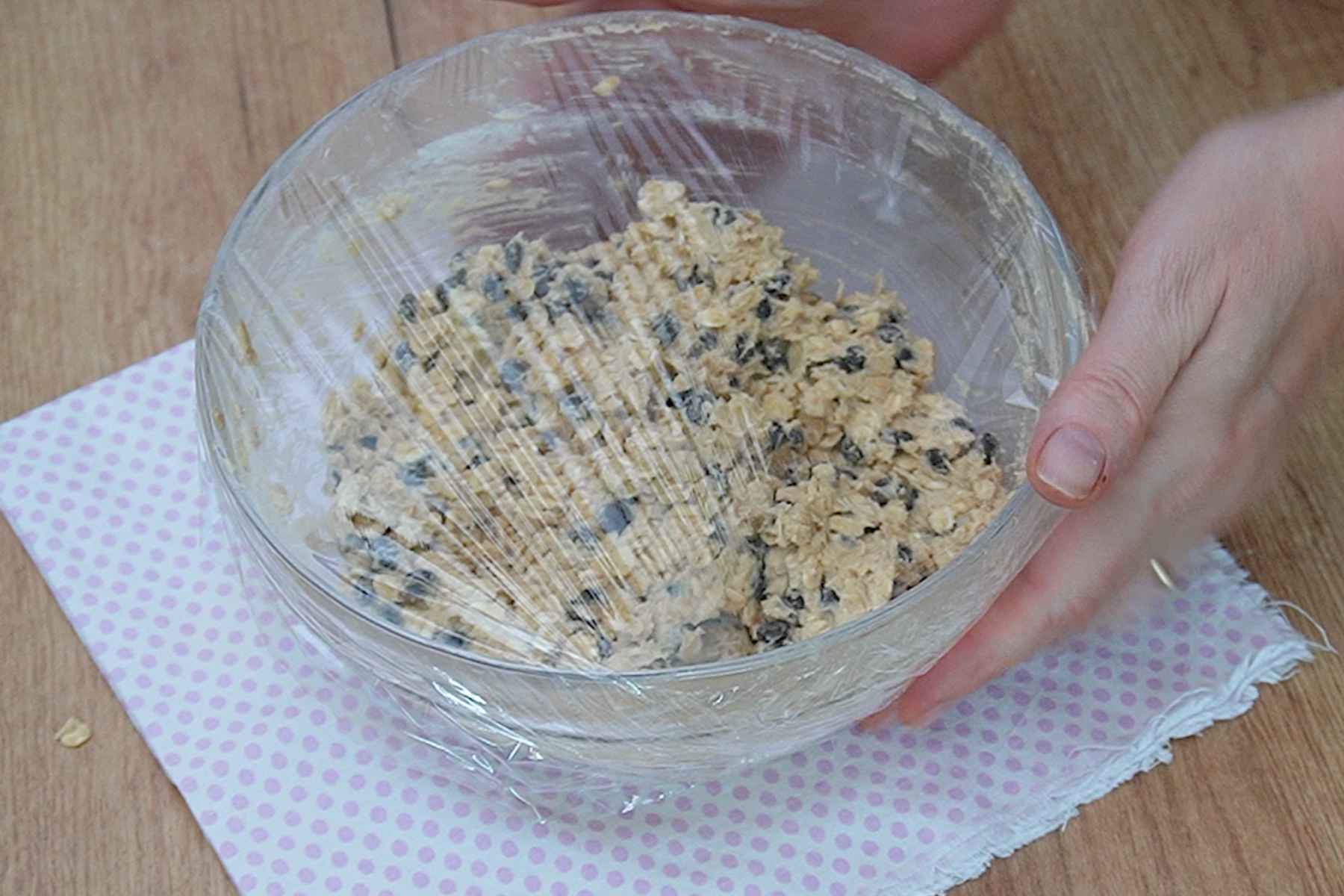 Aluat pentru biscuiți cu ovăz și ciocolată acoperit cu folie înainte de răcirea la frigider