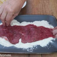 Felie subțire de carne de vițel trecută prin făină înainte de prepararea șnițelului vienez