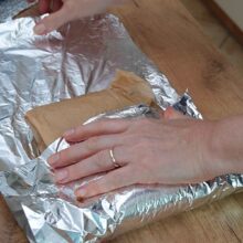 Piept de curcan învelit mai întâi în hârtie de copt și apoi în folie de aluminiu pentru coacere