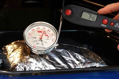 Verificarea temperaturii interne a pieptului de curcan cu termometru cu sondă și termometru digital, la aproximativ 74°C