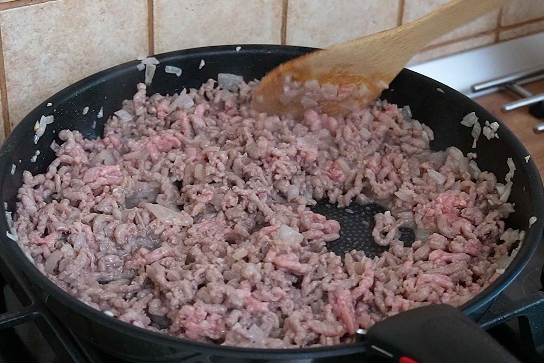 Carne tocată de porc și vită gătită în tigaie împreună cu ceapă pentru umplutura vinetelor