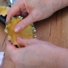 Aluat fraged presat cu degetele pe baza și pereții unei forme metalice pentru coșulețe