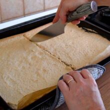 Foaie coaptă de bezea cu nucă tăiată în două pentru montarea prăjiturii Krantz