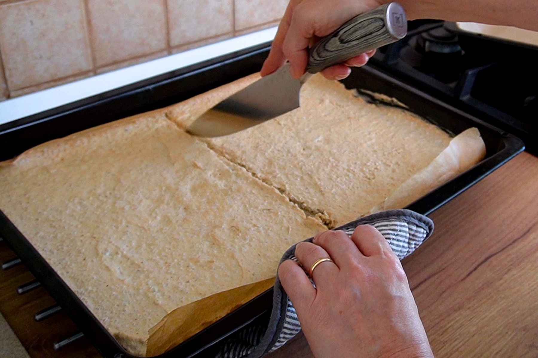 Foaie coaptă de bezea cu nucă tăiată în două pentru montarea prăjiturii Krantz