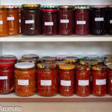 Borcane cu zacuscă de fasole și alte conserve pentru iarnă, așezate pe rafturile cămării