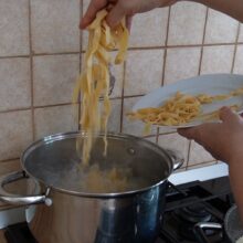 Tăiței lați de casă puși la fiert într-o oală cu apă și sare