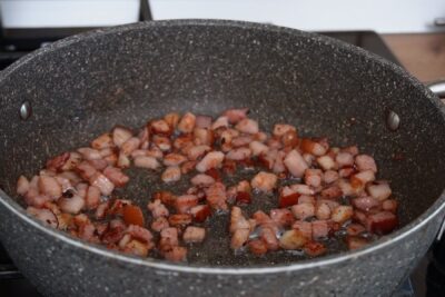 Cubulețe de șunculiță afumată rumenite în tigaie până devin ușor crocante