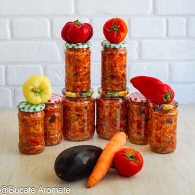 Tocană de legume cu orez pusă în borcane, alături de roșii, ardei, morcov și vânătă