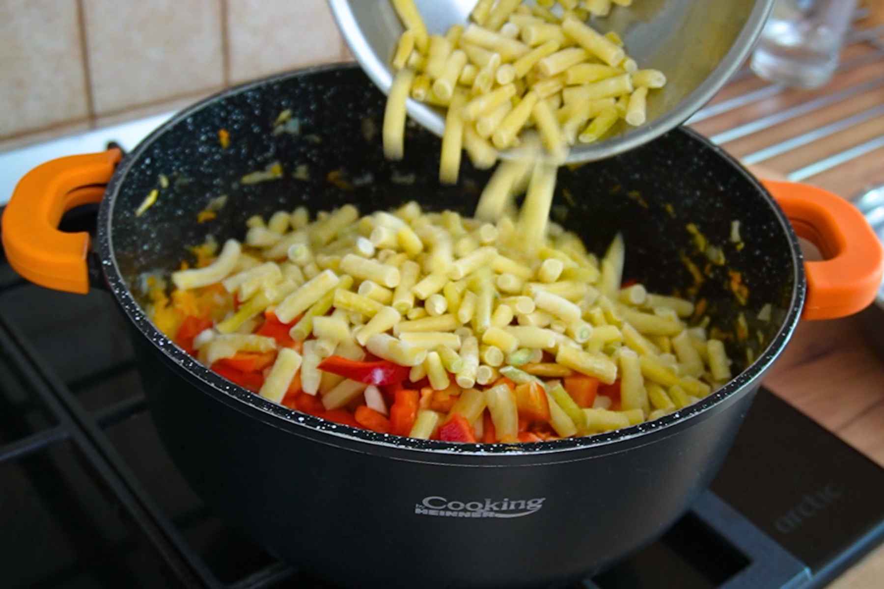 Fasole păstăi galbenă adăugată peste ardei și legume pentru tocana de legume cu orez la borcan