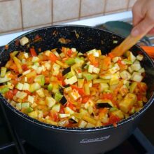 Cuburi de vinete și dovlecei amestecate cu ardei și roșii în tocana de legume pentru iarnă