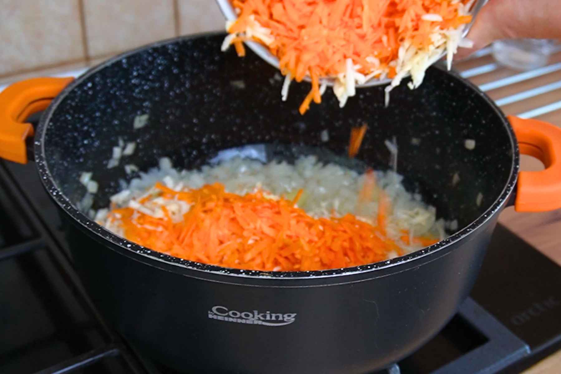 Morcov și țelină rădăcină rase adăugate peste ceapa călită pentru tocana de legume