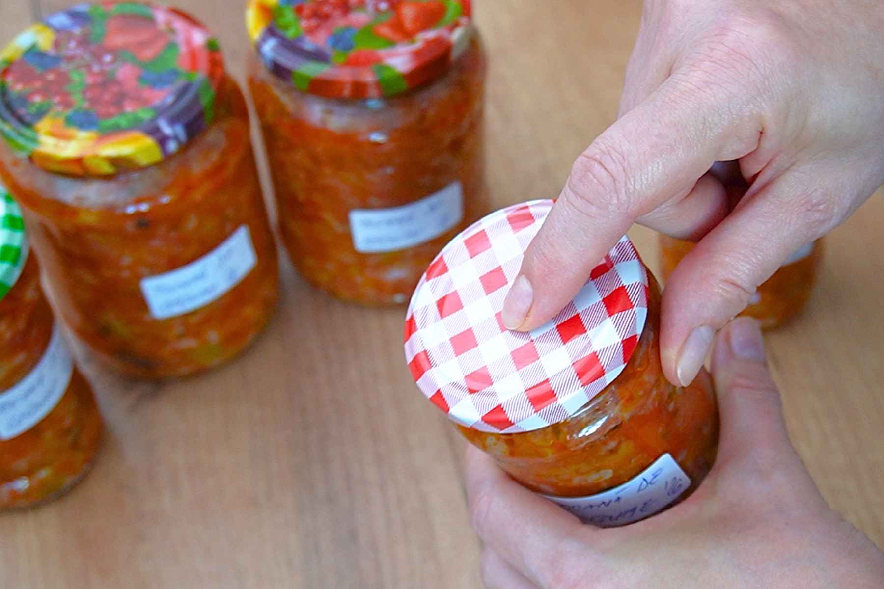 Verificarea capacului unui borcan cu tocană de legume după răcire și sterilizare