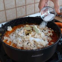 Sare, foi de dafin și boabe de piper adăugate peste fasole și sosul de legume