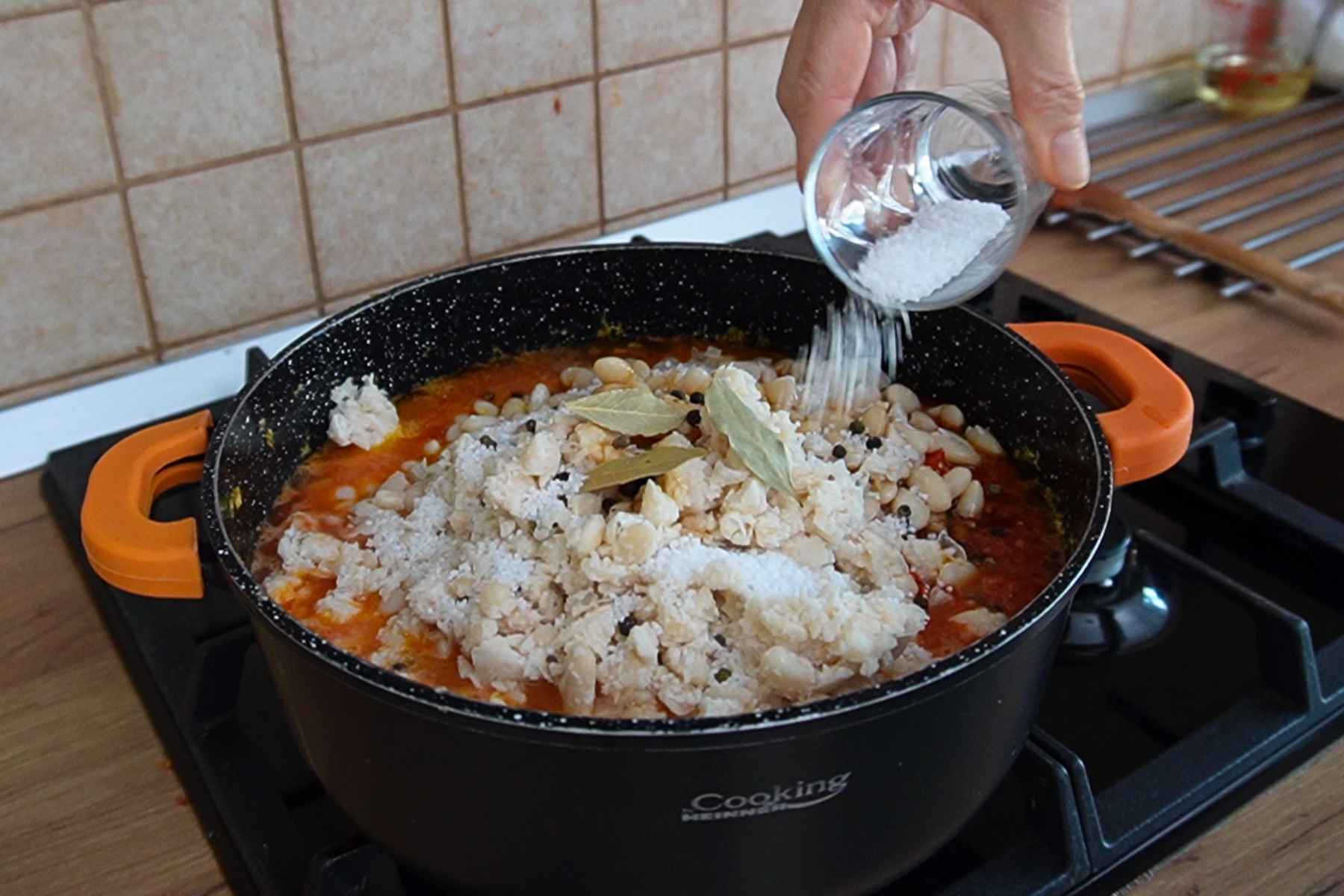 Sare, foi de dafin și boabe de piper adăugate peste fasole și sosul de legume