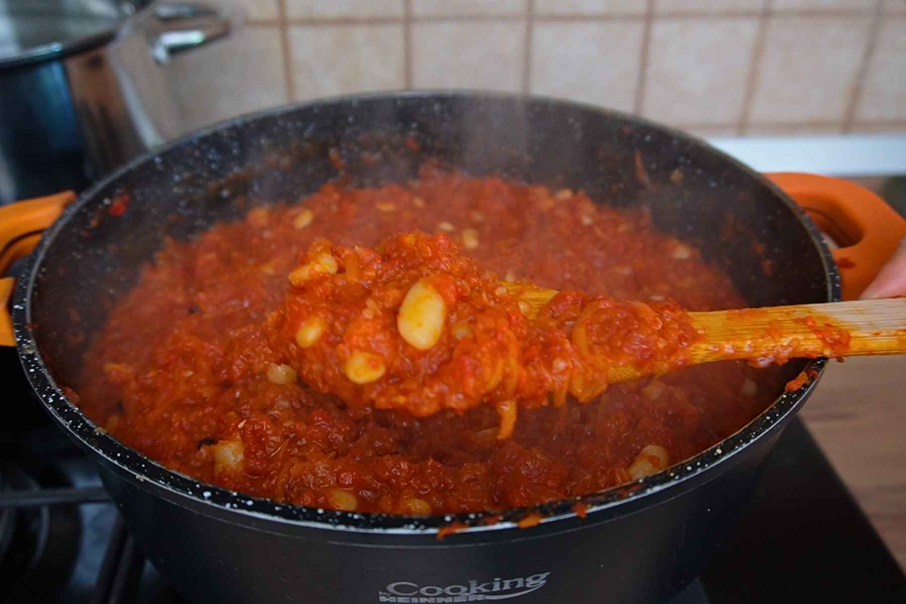 Zacuscă groasă de fasole boabe cu ardei copți, ridicată pe lingura de lemn