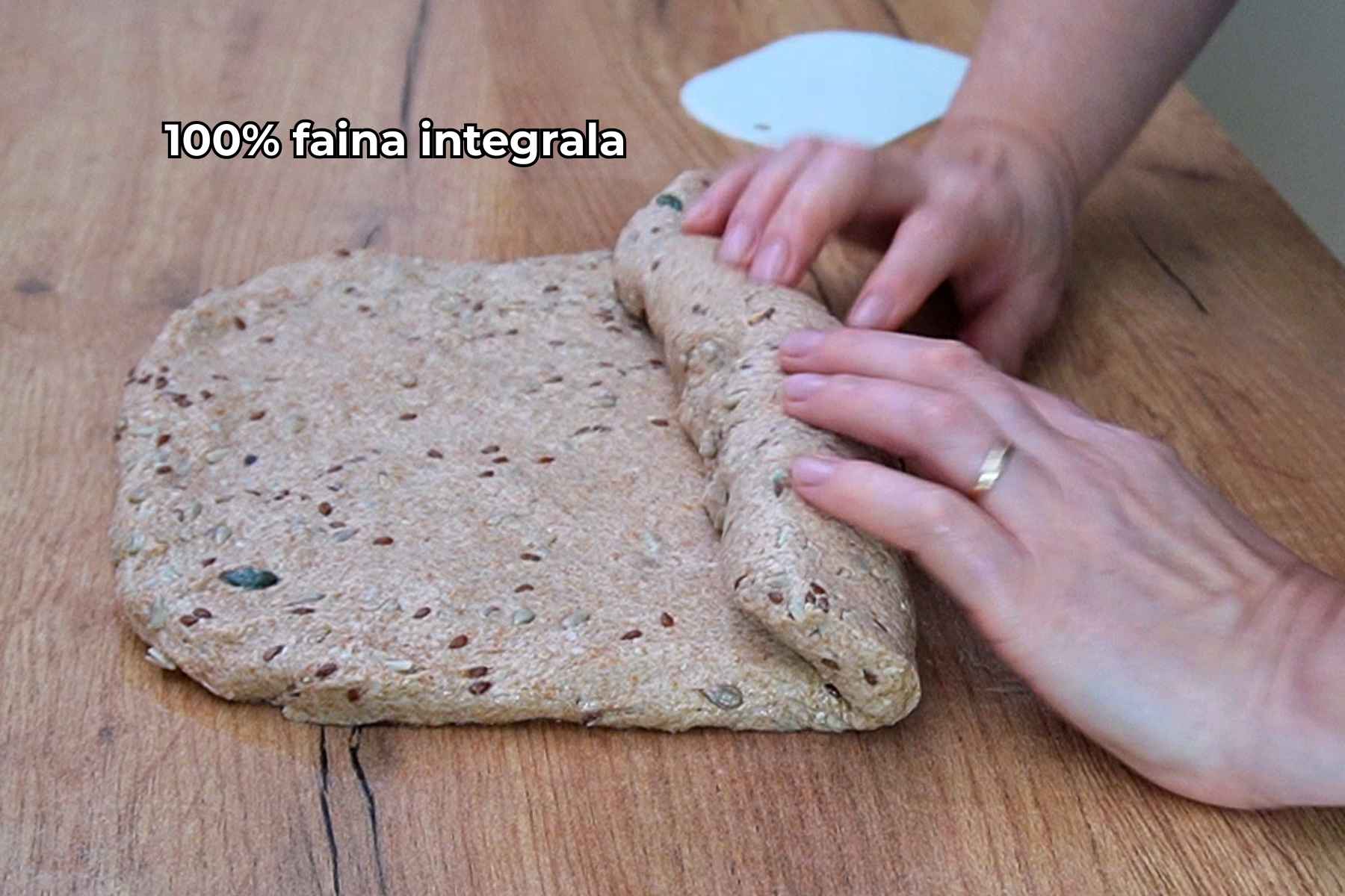 Aluat cu semințe și 100% făină integrală, rulat pentru a fi așezat în tava de pâine