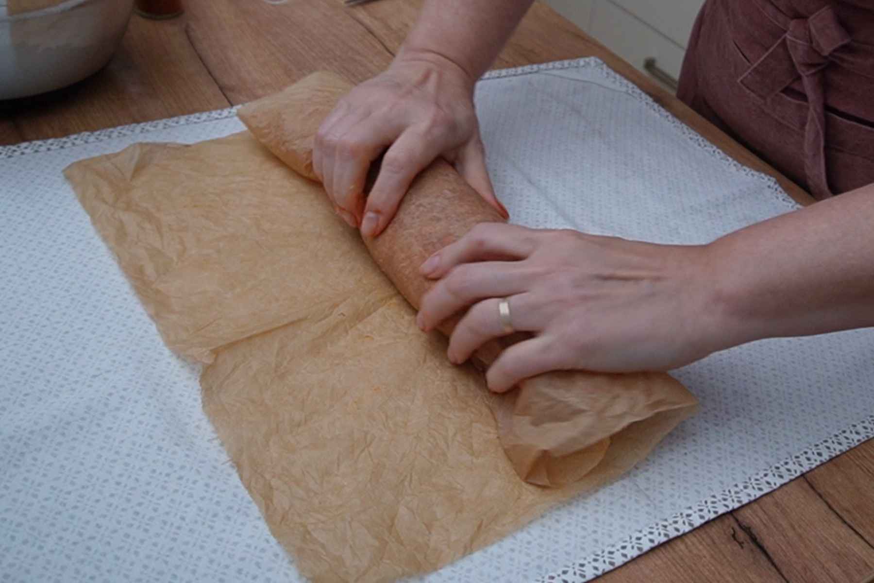 Modelarea unui baton de șuncă de pui prin rularea strânsă a amestecului de carne în hârtie de copt, fără membrană pentru salam.