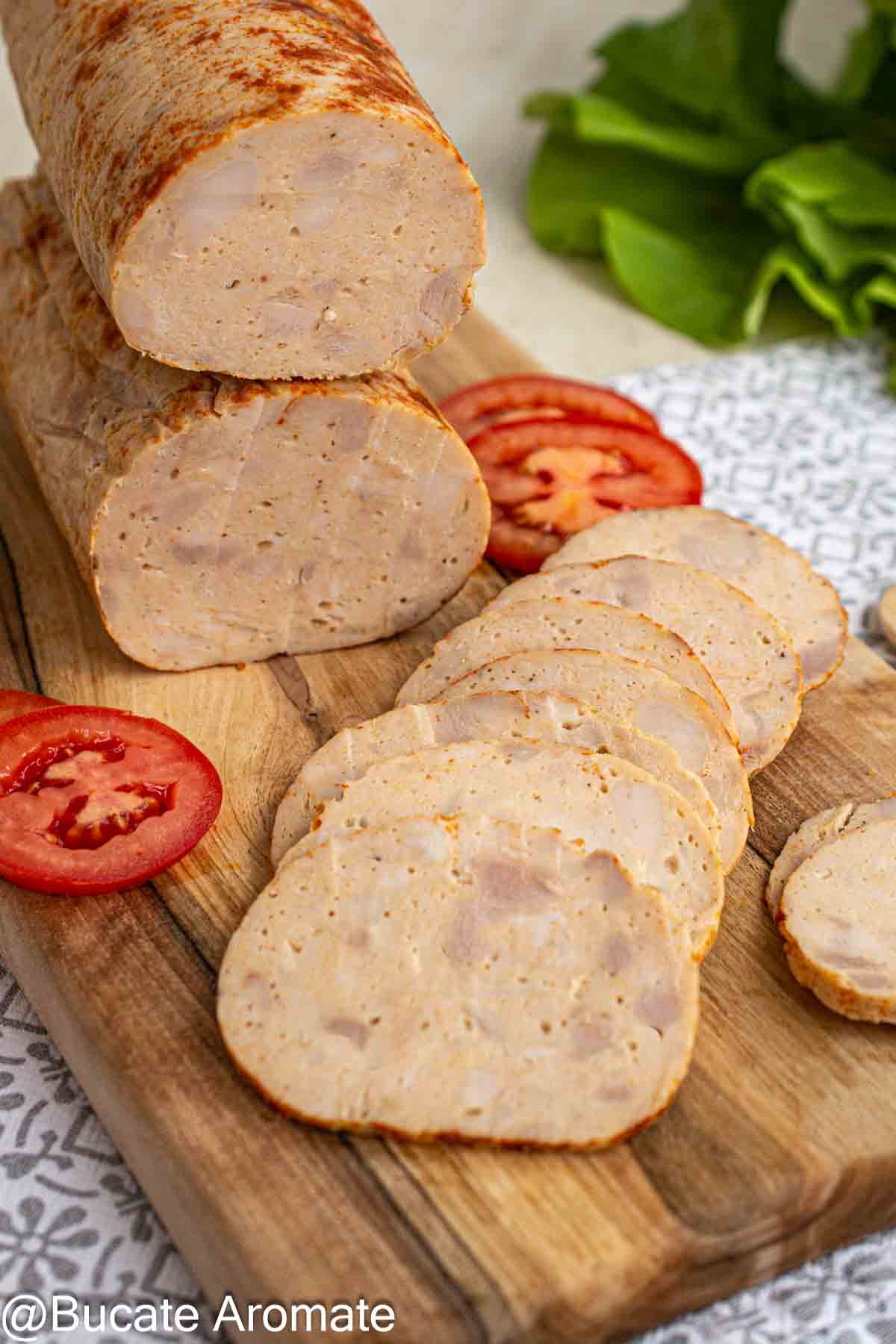 Șuncă de pui de casă tăiată în felii subțiri, cu textură compactă și bucățele de carne vizibile în secțiune.
