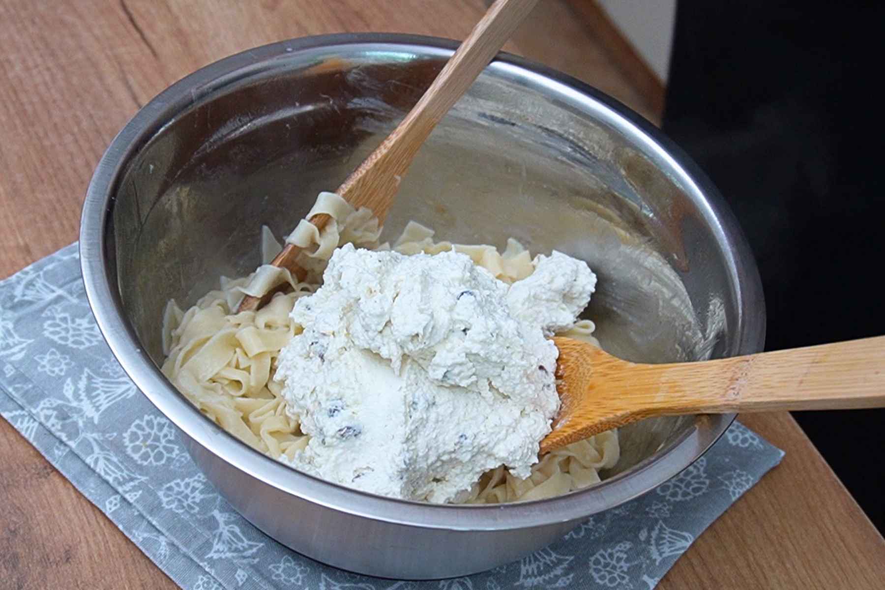 Tăieței fierți amestecați cu cremă de brânză dulce, smântână și stafide