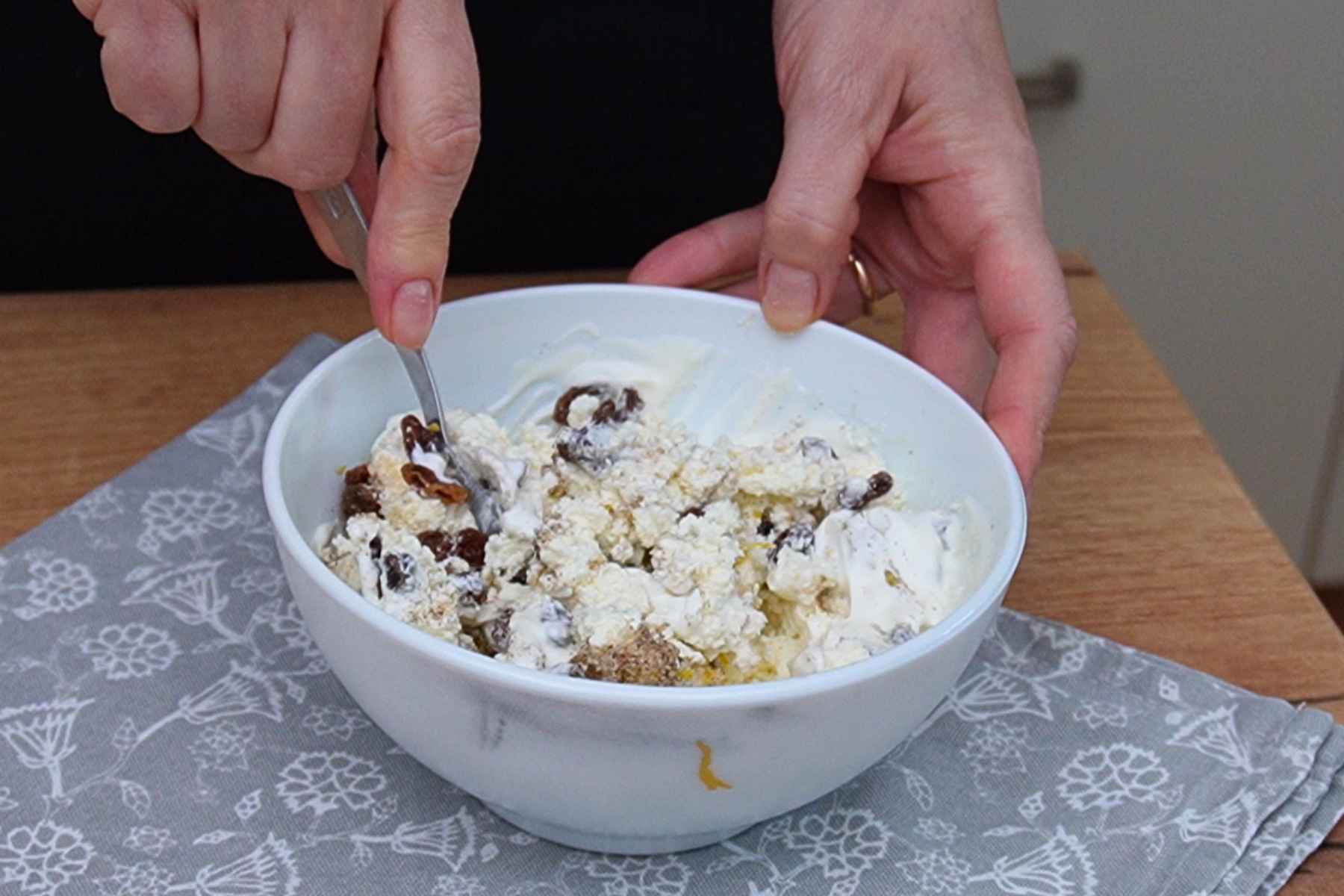 Prepararea cremei de brânză dulce cu smântână, stafide, zahăr vanilat și coajă de lămâie